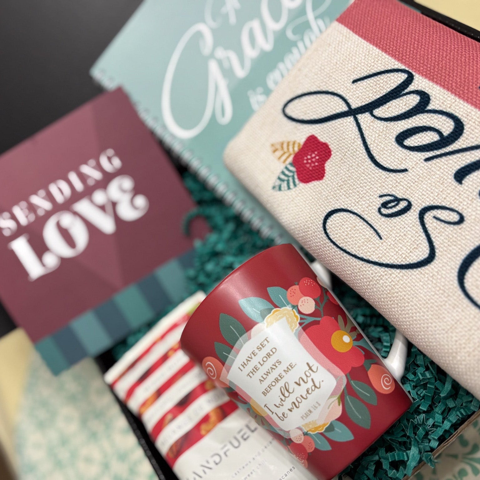 Assorted care package items including a mug, cards, and a box with 'Sending Love' text.